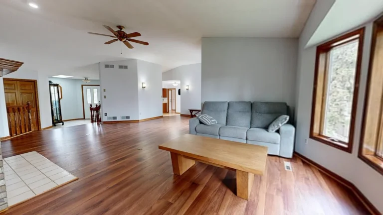 Engineered vs. solid hardwood flooring: what’s the difference? Living room with warm-toned wood-look plank flooring